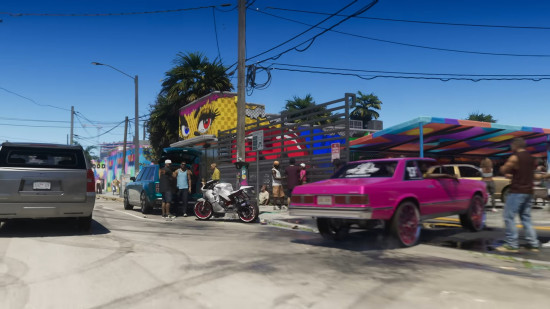 Rua movimentada com carros coloridos e murais vibrantes nas paredes, em um bairro urbano.